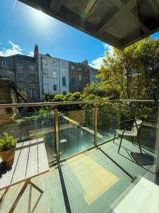 a balcony with a chair and a view of a building at Leevin Stay Apartments City Center in Dublin