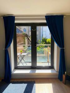 a window with blue curtains in a room at Leevin Stay Apartments City Center in Dublin
