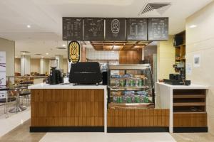 a fast food restaurant with a counter with a refrigerator at Saraya Al Deafah Hotel in Mecca