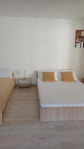 a bedroom with two beds and a table at Casa Carmen in Târgu Ocna