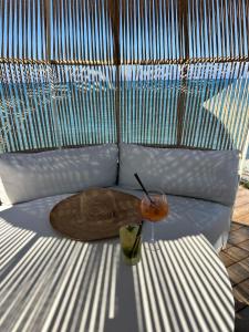a bag and a drink sitting on a couch at Hôtel Pineto in Biguglia