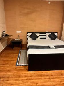 a bedroom with a large bed and a table at Meeraj Residency in Mātigara