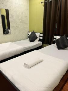 two beds with white sheets and a towel on them at Meeraj Residency in Mātigara +6 photos