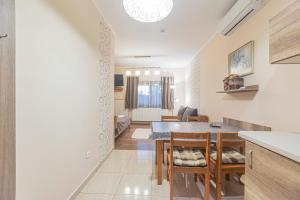 a kitchen and living room with a table and chairs at Besenyei Apartman in Sárvár