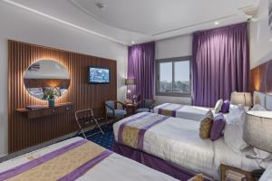 a hotel room with two beds and a mirror at Saraya Al Deafah Hotel in Mecca +45 photos