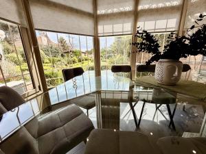 a dining room with a glass table and chairs at Natalie Apartments Athens Airport in Artemida +87 photos
