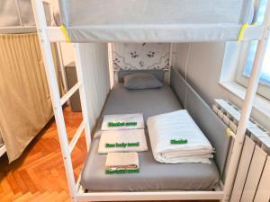 a bunk bed with two pillows and towels on it at Hostel Budva in Budva