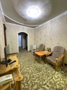 a room with two chairs and a desk with a computer at Turkiston Hotel in Namangan +24 photos