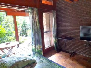 a room with a screened in porch with a television at Grüne Oase mit Terrasse in Appel
