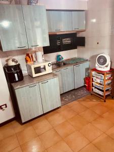a kitchen with white cabinets and a microwave at Villa Iovane Diamond in Ustica