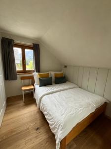 a bedroom with two beds and a chair in it at Ferienwohnung Gaiswinkler in Grundlsee
