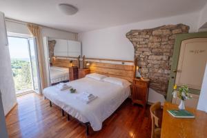 a bedroom with a bed and a stone wall at Albergo Osteria Leso1815 in Bosco Chiesanuova