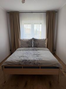a large bed in a bedroom with a window at Apartament Londyn in Pniewy