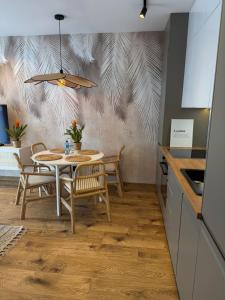 a kitchen and dining room with a table and chairs at Apartament Londyn in Pniewy