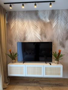 a flat screen tv sitting on top of a white entertainment center at Apartament Londyn in Pniewy