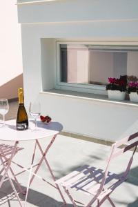 a table with a bottle of wine and a chair at City Boutique in Porto Torres