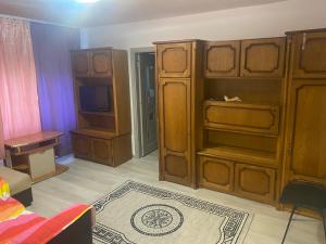 a living room with a large wooden cabinet and a tv at Sofia Apartament in Drobeta-Turnu Severin