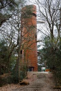 a red brick tower in the middle of a forest at De Bosberg Villa in Appelscha