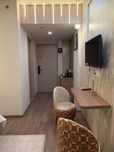 a room with a table and chairs and a television at The Kaksh in Greater Noida +6 photos