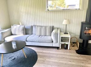 a living room with a couch and a table at Charming Beach Cottage In Gilleleje in Gilleleje
