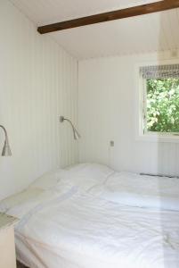 a white bed in a room with a window at Charming Beach Cottage In Gilleleje in Gilleleje