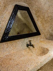 a mirror on the floor with a faucet in a sink at La Maison Chocolat in Nianing +50 photos