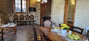 a dining room with tables and chairs and a fireplace at Sunset Castle House with Pool in Xagħra