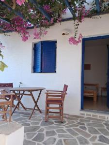 a patio with a table and chairs and flowers at Pyrgis Glyfades studios in Glifades