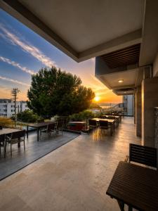 an outdoor patio with tables and chairs at sunset at Calis Hotel in Çeşme
