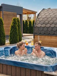 a man and a woman sitting in a hot tub at Wyspa Wisła Przyjazna Przystań Stężyca in Stężyca