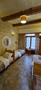 a room with three beds and a mirror in it at Sunset Castle House with Pool in Xagħra