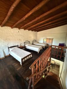 an attic room with four beds and a staircase at Dulce Claudina 3 in Mercedes