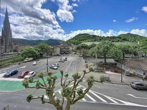 a city street with cars parked on the road at Le Nid Douillet Studio in Saint-Affrique