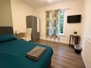 a bedroom with a bed and a television and a window at Middlesbrough The Longlands Hotel in Middlesbrough