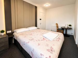 a bedroom with a bed with a table and a chair at Middlesbrough The Longlands Hotel in Middlesbrough +2 photos