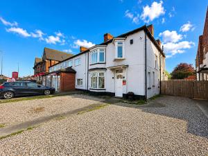 a white house on a street with a car at Middlesbrough The Longlands Hotel in Middlesbrough
