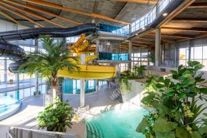 a pool in a building with a water slide at Spa Tervise Paradiis in Pärnu