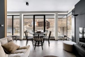 a living room with a table and chairs at Les Chalets du Grand Hôtel in Saint-Chaffrey