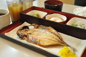 a plate of food with a fish on a table at KOKO HOTEL Numazu Ekimae in Numazu
