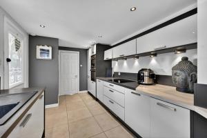 a kitchen with white cabinets and a counter top at Finest Retreats - Seamill Beach House in Seamill