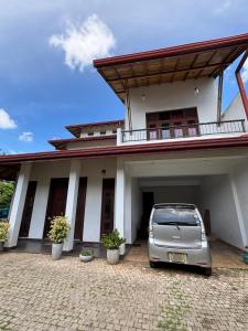 a car parked in front of a house at Nymph Villa in Pannipitiya