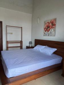 a bedroom with a bed and a painting on the wall at Nymph Villa in Pannipitiya