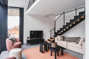 a living room with a couch and a fireplace at Les Chalets du Grand Hôtel in Saint-Chaffrey