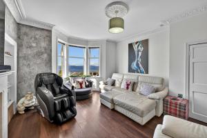 a living room with a couch and a chair at Finest Retreats - Seamill Beach House in Seamill