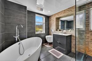 a bathroom with a tub and a sink and a toilet at Finest Retreats - Seamill Beach House in Seamill +30 photos