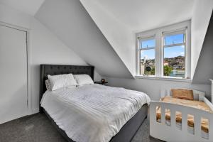 a white bedroom with a bed and a window at Finest Retreats - Seamill Beach House in Seamill