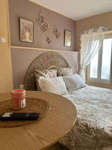 a bedroom with a bed and a table with a remote control at Le nid gourmand in Andryes