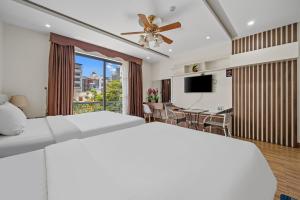 a bedroom with a large bed and a dining room at AVA Hotel & Apartment in Danang