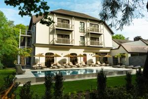 a large white building with a swimming pool in front of it at Corsendonk Hooge Heyde in Lichtaart