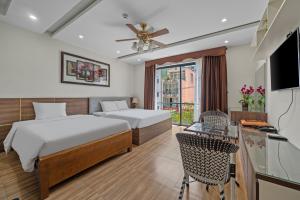 a hotel room with two beds and a television at AVA Hotel & Apartment in Danang